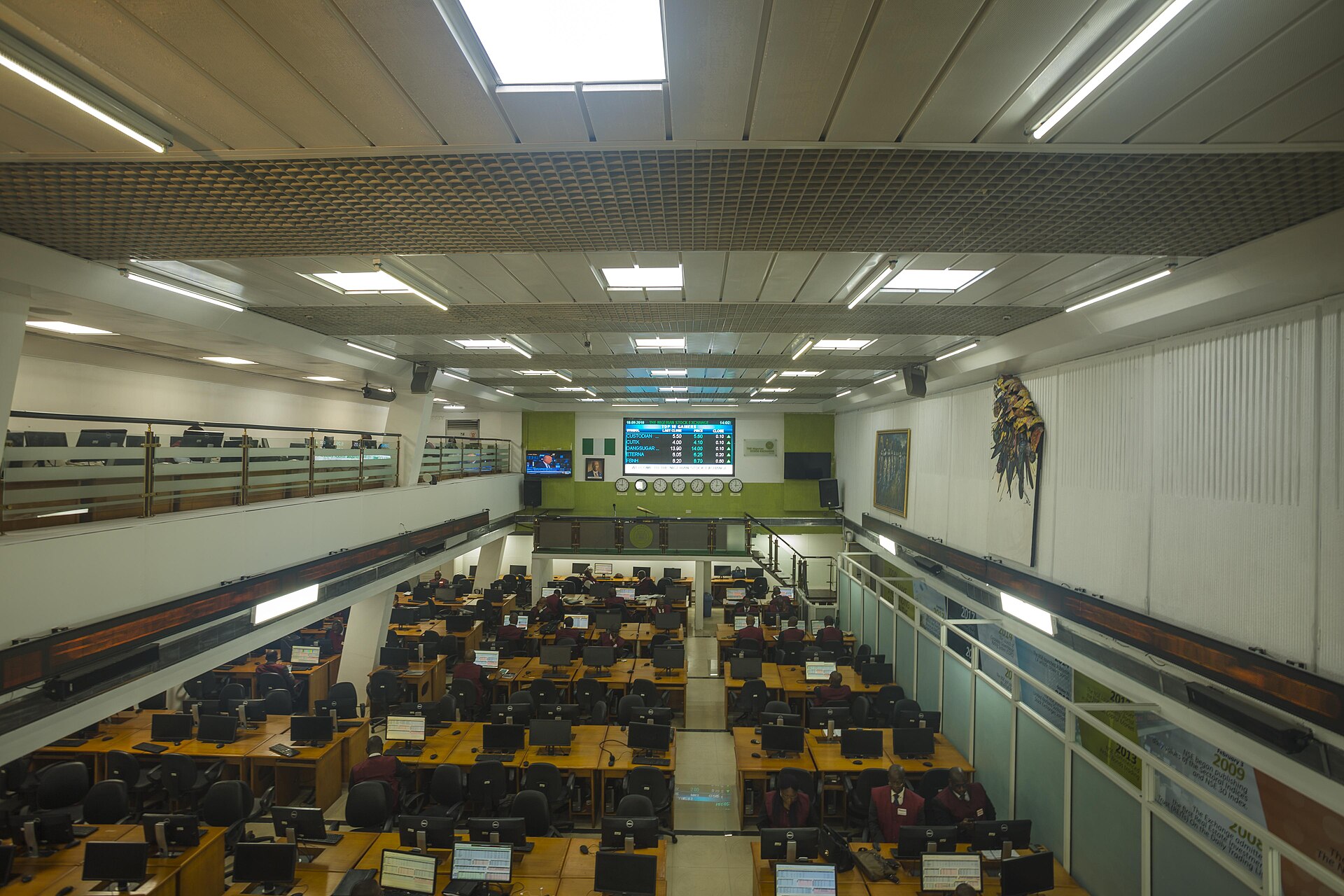 A stock exchange trading floor with rows of desks and screens